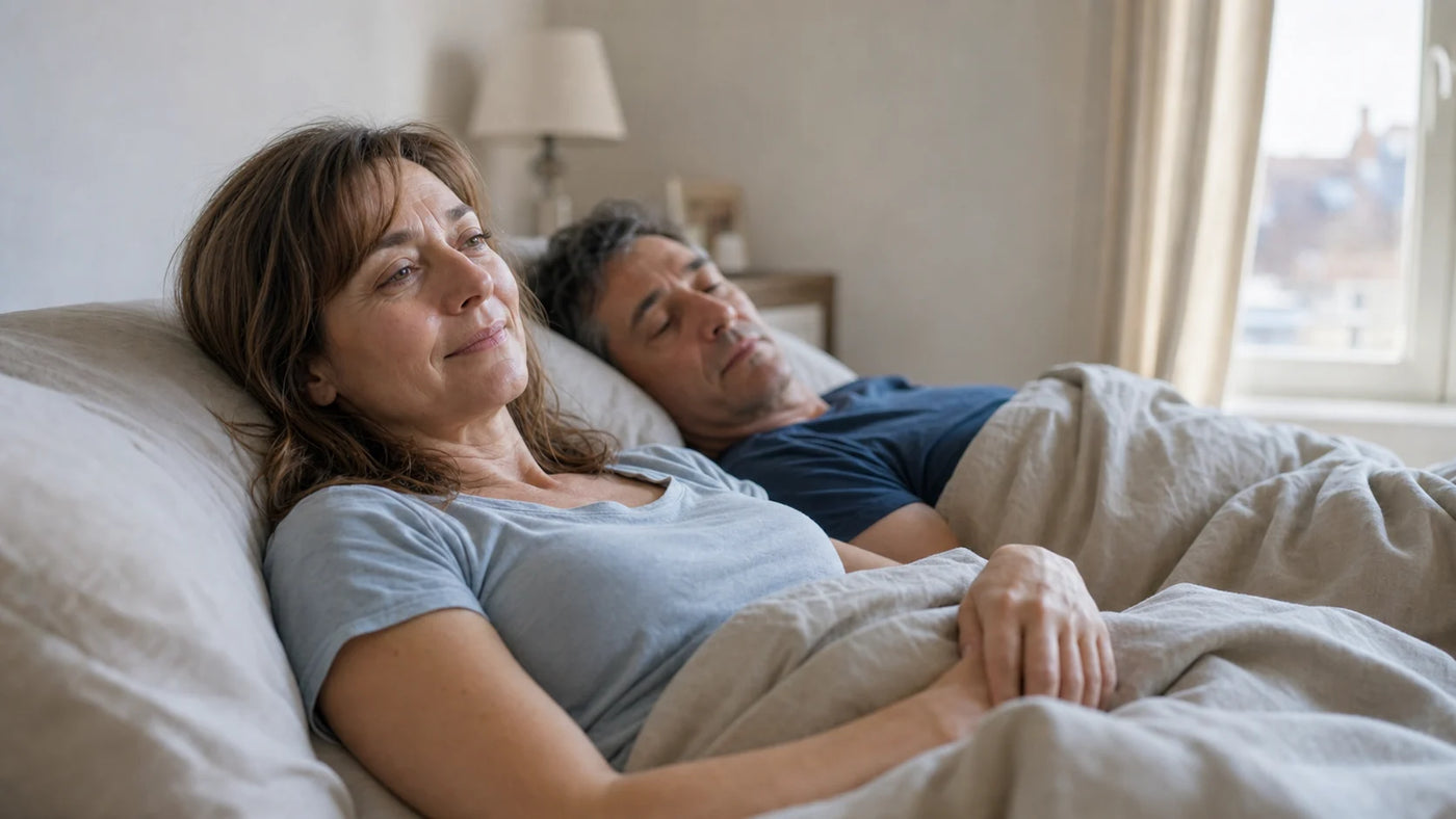 Femme reposée au réveil avec son conjoint dans une chambre lumineuse